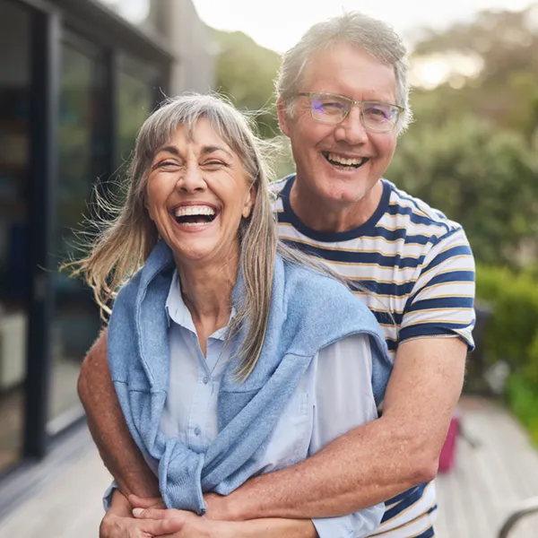 senior couple outdoors embracing and smiling