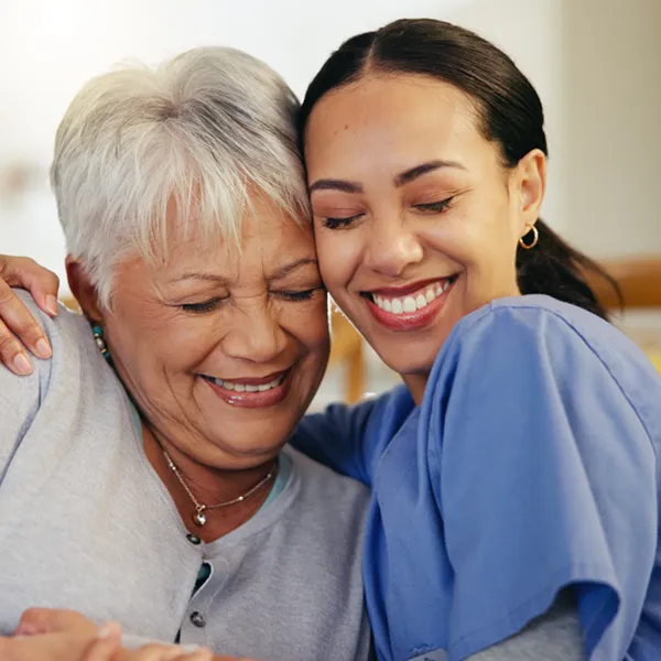 senior woman and young woman embracing and smiling