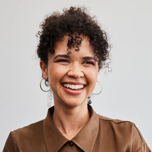 young businesswoman smiling while standing with her arms crossed