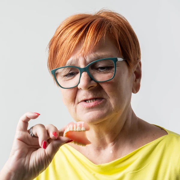 mature woman inspecting her top denture